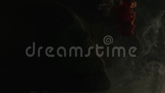 水中的红白墨水和黑色背景的骷髅视频的预览图