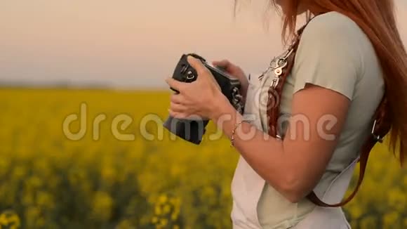 年轻女子摄影师拿着相机特写视频的预览图