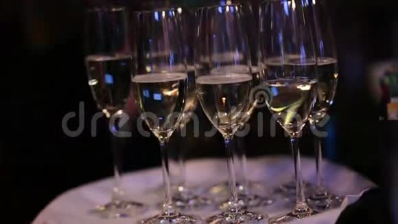 一排玻璃杯里面有香槟酒可供餐厅客人饮用视频的预览图
