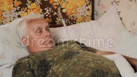老人带着一个巨大的温度计病在床上手臂下面有个有趣的温度计视频的预览图