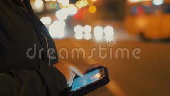 夜间在城市户外使用平板电脑的女性特写镜头只有一双手可以看到视频的预览图