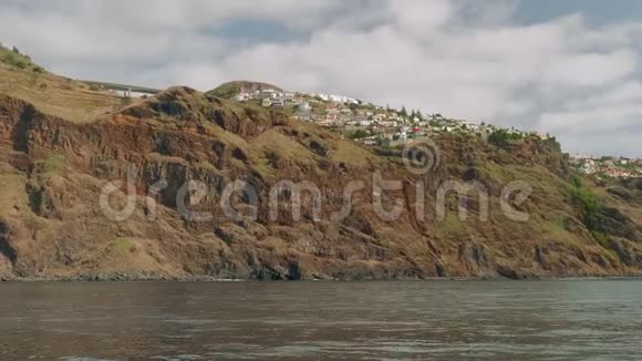 马德拉岛的景色它的悬崖岸白色的房子和建筑物道路和休息从帆船上观看视频的预览图