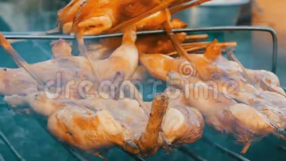 全鸡胴体烤架串在木棒上烤在烤架上泰国街头食品视频的预览图