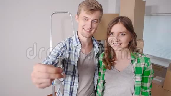 年轻的幸福夫妇带着盒子拿着平钥匙视频的预览图