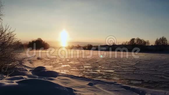 冰封的冰雪覆盖的河水上冬日的霜落日视频的预览图