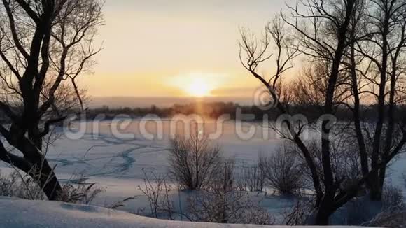 冰封的冰雪覆盖的河水上冬日的霜落日视频的预览图
