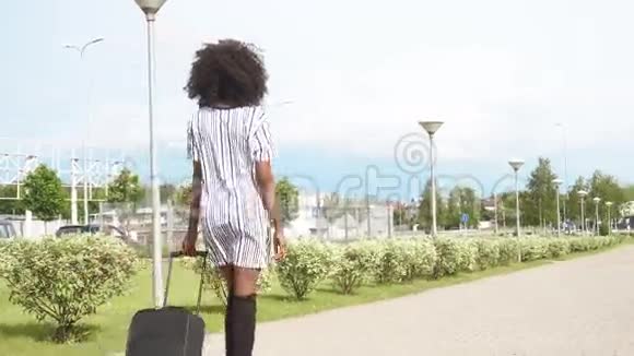 优雅微笑的非裔美国商务女士带着行李前往机场的完整背影商务视频的预览图