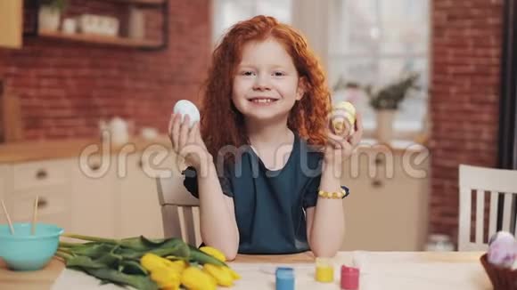 欢快的红头小女孩在厨房背景上玩复活节彩蛋的肖像她在欢呼视频的预览图