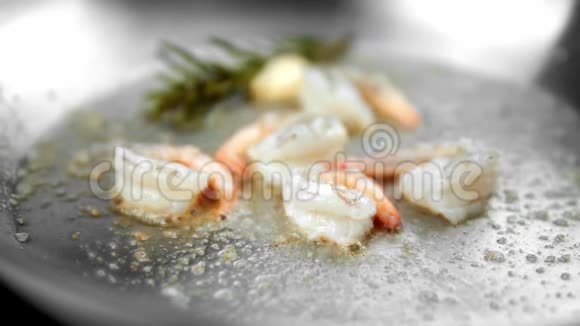用大蒜和迷迭香在煎锅上的虾苗上视频的预览图