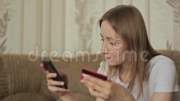 年轻的高加索女人在智能手机上从互联网上购买商品视频的预览图