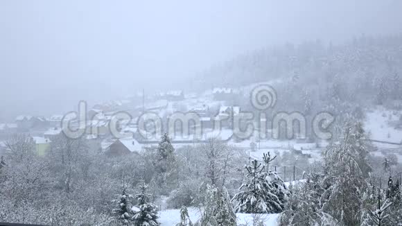 雪落在木山脚下的小村庄视频的预览图