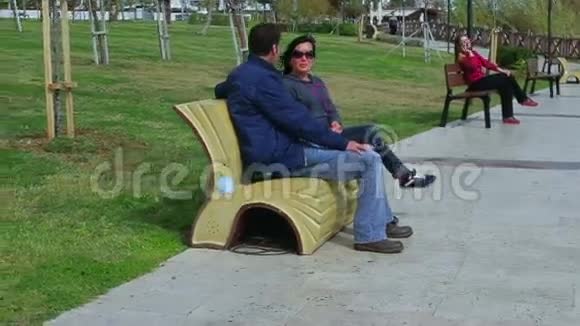情侣们坐在公园长椅上聊天视频的预览图