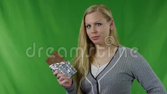 有敏感牙齿的年轻女人吃巧克力敏感牙齿视频的预览图