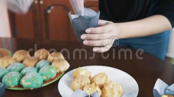 女人的糕点厨师手在松饼上做漩涡盘子上有奶油视频的预览图