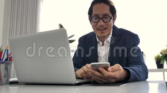 商务人员在办公室使用笔记本电脑和手机视频的预览图