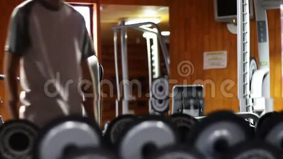 健身房里的那个人用体重摇动二头肌视频的预览图