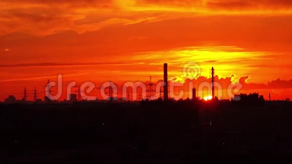 工业橙色日落太阳落在管道和电源塔后面4K实时长镜头视频的预览图