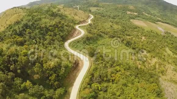 一条蜿蜒的长路穿过青山布桑加岛死因空中观景菲律宾视频的预览图