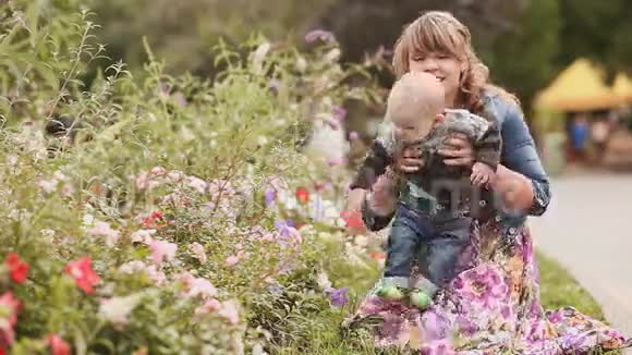 快乐的母亲和孩子在大自然中的花朵视频的预览图