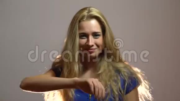美丽的金发女郎穿着蓝色礼服在工作室跳舞视频的预览图