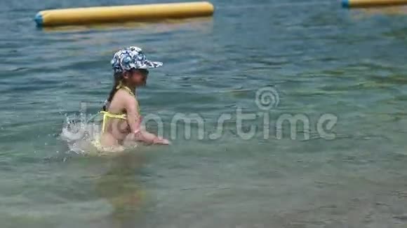 小女孩在水里玩宝贝在河里玩得开心溅得水花慢动作视频的预览图