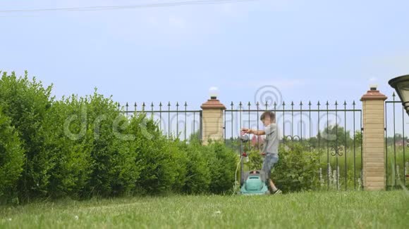 十岁的男孩用大割草机割草视频的预览图