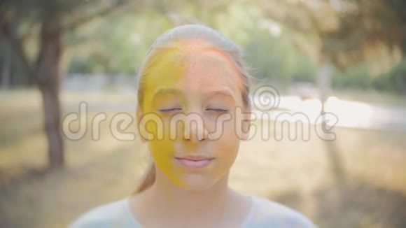 一个可爱的女孩的肖像画在霍利节的颜色视频的预览图