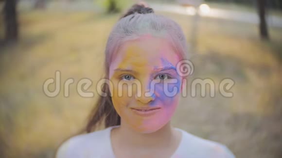 一个可爱的女孩的肖像画在霍利节的颜色视频的预览图