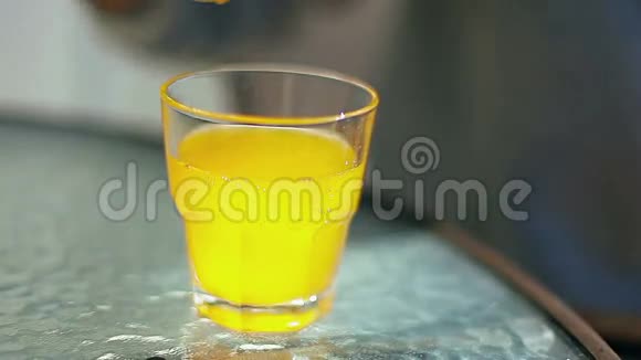 女性手在杯子里加入柠檬和一根吸管加入黄色鸡尾酒视频的预览图