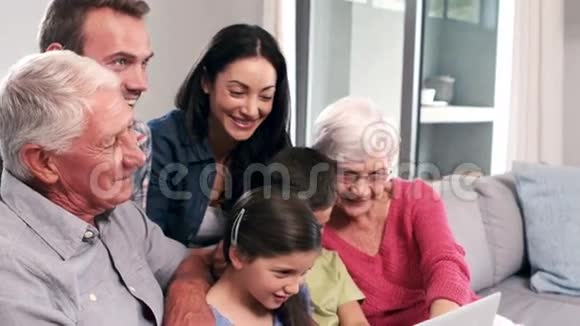 可爱的多代家庭使用笔记本电脑沙发视频的预览图