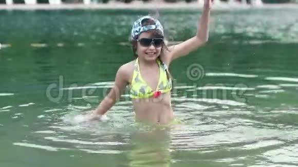 小女孩在水里玩宝贝在河里玩得开心溅得水花慢动作视频的预览图