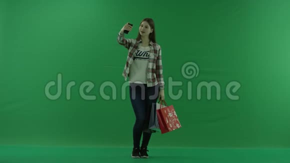 带购物袋的女孩在绿色屏幕上自拍视频的预览图