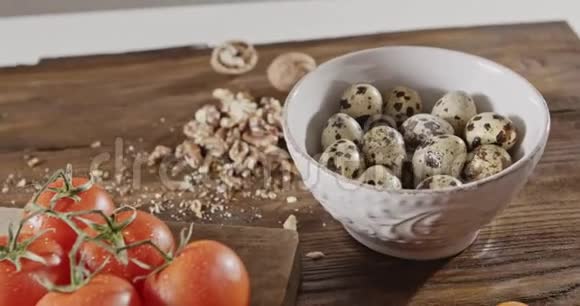 色拉烹饪的天然原料背景陶瓷碗里的鹌鹑蛋湿西红柿核桃视频的预览图