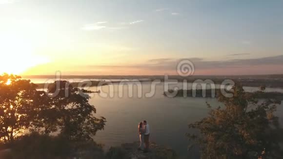 快乐的一对夫妇在悬崖边拥抱空中嘘声视频的预览图