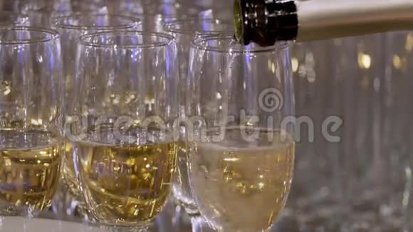 瓶子的特写在玻璃杯里倒香槟从瓶子里倒香槟很漂亮的香槟酒视频的预览图