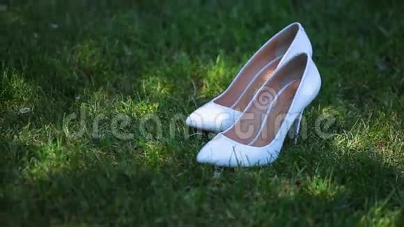 新娘的白色结婚鞋在草地上视频的预览图