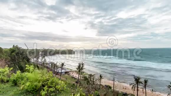 热带景象日落时间在印度尼西亚巴厘岛的巴兰干海滩上流逝从悬崖上看4K时程视频的预览图