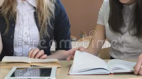 两个女孩互相交谈看课本视频的预览图