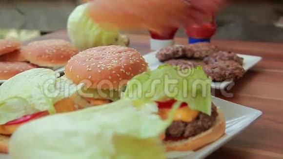 手把新鲜的生菜放在汉堡上视频的预览图