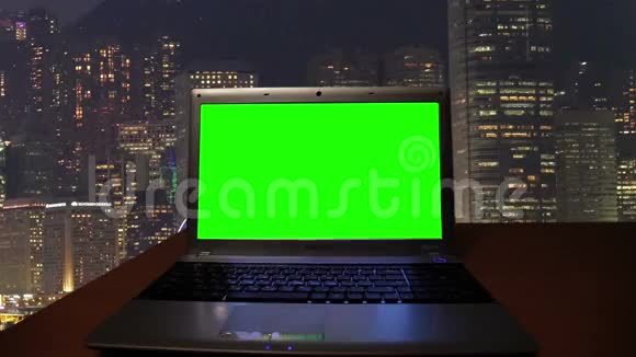在黑暗的房间里有绿色屏幕的笔记本视频的预览图
