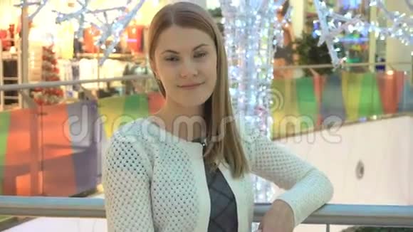 商场里漂亮迷人的年轻女人站着微笑着进入镜头购物概念视频的预览图