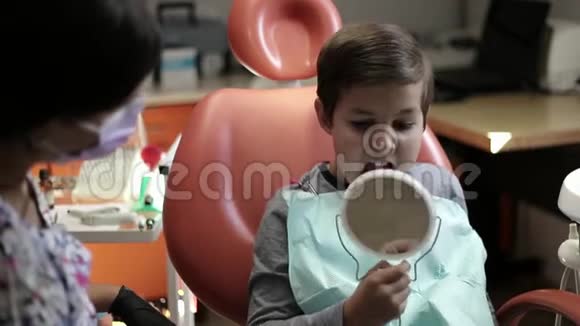 医学牙科和保健概念牙科诊所中有儿童病人的女牙医调整椅子视频的预览图