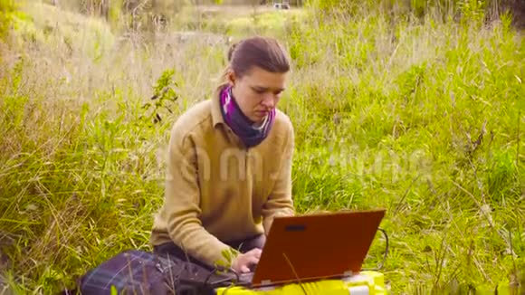 在森林里用笔记本电脑工作的女科学家生态学家视频的预览图