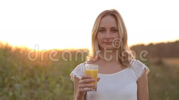 年轻女子在外面喝橙汁视频的预览图