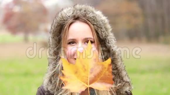 年轻的女人在玩树叶和微笑视频的预览图