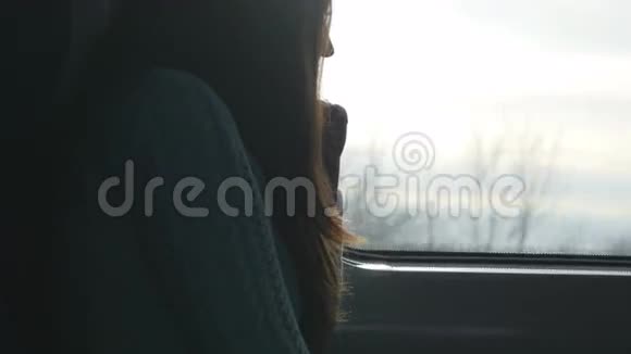 年轻女子坐火车时看着窗户在铁路上旅行的迷人女孩的形象视频的预览图