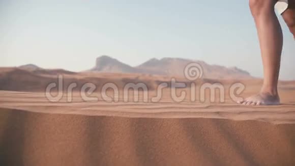 女人的特写双脚沉在沙子里在沙漠中行走视频的预览图