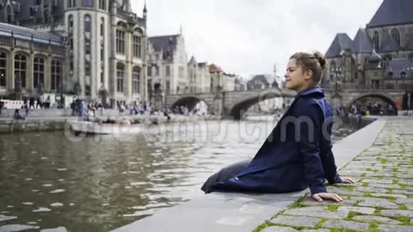 女孩坐在河堤上视频的预览图