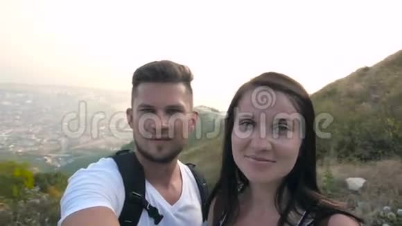 山上的年轻夫妇带着背包做夏日的夜晚视频的预览图