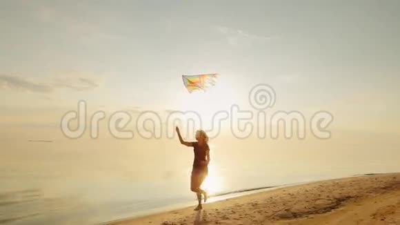 快乐的年轻女人带着风筝跑步视频的预览图